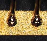 FIGURE 4. A solid 0.004-in. diameter gold wire welded to gold plated metalized pad. FIGURE 4. A solid 0.004-in. diameter gold wire welded to gold plated metalized pad.