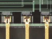 FIGURE 3. 0.015-in. thick gold coated copper flat wire welded to metalized pads. FIGURE 3. 0.015-in. thick gold coated copper flat wire welded to metalized pads.