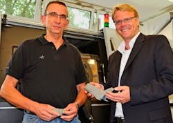 Jürgen Mengering and Markus Boje stand in the DLR's LaserCusing lab with their scaled titanium model of the Alpha space vehicle. Jürgen Mengering and Markus Boje stand in the DLR's LaserCusing lab with their scaled titanium model of the Alpha space vehicle.