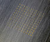 Small gold spots are laser-clad onto stainless steel.
