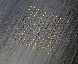 Small gold spots are laser-clad onto stainless steel.