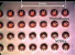 A photomicrograph shows the back of the IBM Holey Optochip with lasers and photodetectors visible through substrate holes. A photomicrograph shows the back of the IBM Holey Optochip with lasers and photodetectors visible through substrate holes.