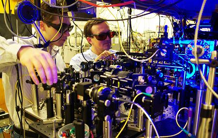 Georgia Tech graduate student Yaroslav Dudin and professor Alex Kuzmich (l-r) adjust optics as part of research into the production of single photons for use in optical quantum information processing and the study of certain physical systems.