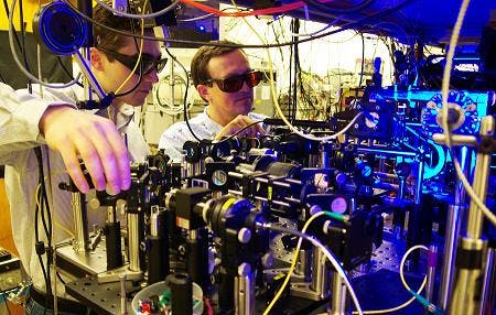 Georgia Tech graduate student Yaroslav Dudin and professor Alex Kuzmich (l-r) adjust optics as part of research into the production of single photons for use in optical quantum information processing and the study of certain physical systems.
