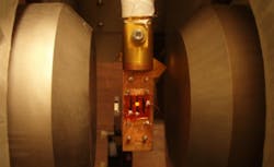 A spintronic OLED glows orangish (center) when the device, chilled well below freezing, is exposed to a magnetic field from the two poles of an electromagnet located on either side of the device. A spintronic OLED glows orangish (center) when the device, chilled well below freezing, is exposed to a magnetic field from the two poles of an electromagnet located on either side of the device.