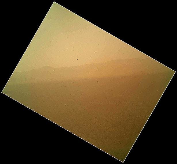 The landscape is shown to the north of NASA&apos;s Mars rover Curiosity in this first image acquired by the Mars Hand Lens Imager (MAHLI), revealing the north wall and rim of Gale Crater. The image is murky because the MAHLI&rsquo;s removable dust cover is apparently coated with dust blown onto the camera during the rover&apos;s terminal descent. The dust cover will be removed in the coming weeks.