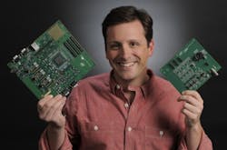 Goddard technologist Jonathan Pellish holds a Goddard-developed digital test board (larger) and the IRAD-developed daughter card containing the analog-based data-processing integrated circuit. The daughter card snaps into the digital test board and will be used to test a number of spaceflight processing applications.
