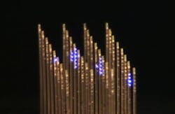 An optical image of the 3D array for optogenetics research shows individual light ports illuminated; the array looks like a series of fine-toothed combs laid next to each other with their teeth pointing in the same direction.