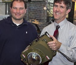 Paul Lang (right), director of CIRCM programs at Northrop Grumman in Rolling Meadows, IL, presents Clinton Sprately of Program Management Countermeasures, U.S. Army, with the initial delivery of CIRCM hardware under acceptance testing procedure. (Courtesy Northrop Grumman)