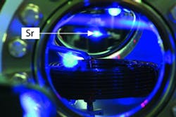 Strontium atoms are cooled and stored in an ultra-high-vacuum chamber. One of the blue fluorescent blobs is a cloud of cold strontium atoms. Strontium atoms are cooled and stored in an ultra-high-vacuum chamber. One of the blue fluorescent blobs is a cloud of cold strontium atoms.