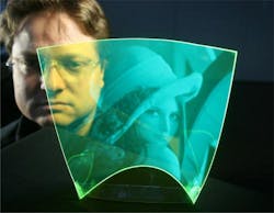 A thin-film luminescent concentrator (LC) creates a flexible, fully transparent, scalable, and low-cost polymer film. The approach reconstructs grayscale images focused onto the LC surface. This image shows Bayer Makrofol LISA Green LC film that absorbs blue and re-emits green light.
