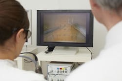 A surgeon practices sewing up a wound without a direct view. Doing so is more efficient with 3D screens. A surgeon practices sewing up a wound without a direct view. Doing so is more efficient with 3D screens.