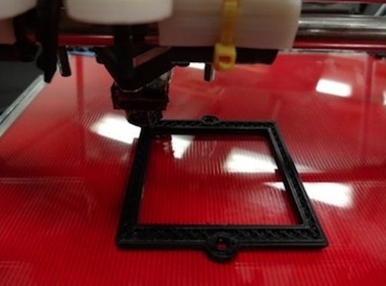 An open-source 3D printer prints an optical component, in this case a filter bracket.