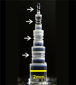 This photo shows four NIST-created glass resonators with diameters (top to bottom) of 0.36, 0.71, 1.2, and 1.5 mm. Smaller cavities produce frequency combs with wider spacing between the comb teeth.