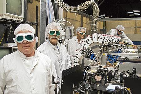The Boeing Thin Disk Laser system, which integrates a series of high-power industrial lasers to generate one concentrated, high-energy beam, exceeded required thresholds for power and beam quality during a demonstration for the Department of Defense&apos;s Robust Electric Laser Initiative (RELI) effort. In this photo, Boeing Thin Disk Laser engineers work with the system&apos;s main optical bench.