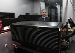 Don Shaw, senior director of product management at Christie stands behind the first laser digital projector installed in a commercial venue.