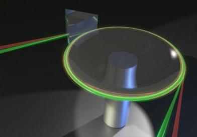 An artist's concept shows red and green light prism-coupled into a crystalline resonator; slight changes in the relative wavelengths of the green and red light within the crystal reveal the resonator's temperature.