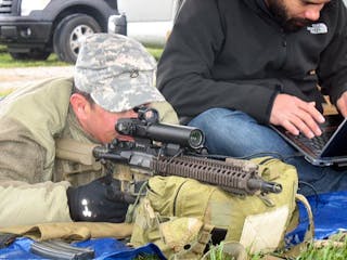 A member of the U.S. Army Special Forces, left, demonstrates the Rapid Adaptive Zoom for Assault Rifles prototype developed at Sandia National Laboratories. (Image credit: Sandia National Laboratories)