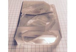 A macroscopic chamber holds a condensed photonic mesh. A macroscopic chamber holds a condensed photonic mesh.