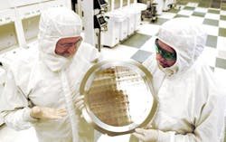 Michael Liehr (left) of SUNY Polytechnic Institute&apos;s Colleges of Nanoscale Science and Engineering and Bala Haran (right) of IBM Research inspect a wafer containing 7-nm-node test chips in a clean room in Albany, NY. IBM Research, working with alliance partners at SUNY Poly CNSE, has produced the semiconductor industry&apos;s first 7-nm-node test chips with functional transistors.