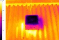 An infrared image reveals the temperature difference between the new polymer/silver surface (center) and an existing cool roof used in testing.