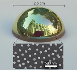 A curved optical surface is covered with a coating that absorbs all red light, giving the surface a green tint. The surface is covered with 100 nm silver cubes (inset).