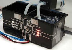 FIGURE 4. Capacitive sensor circuit printed on molded PA6 tank. Surface mount devices connected and interconnects printed using Aerosol Jet process. Project funded by: Bayerische Forschungsstiftung. Project Partners. FIGURE 4. Capacitive sensor circuit printed on molded PA6 tank. Surface mount devices connected and interconnects printed using Aerosol Jet process. Project funded by: Bayerische Forschungsstiftung. Project Partners.