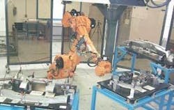 FIGURE 1. In the flexible welding cell concept the robot is located in the center of a half-circle on which perimeters are three stations holding fixtures with multiple parts on each fixture. FIGURE 1. In the flexible welding cell concept the robot is located in the center of a half-circle on which perimeters are three stations holding fixtures with multiple parts on each fixture.