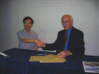 Prof. W.B. Lee and ILS Editor-In-Chief David Belforte shake hands to seal an agreement to foster technology exchange.