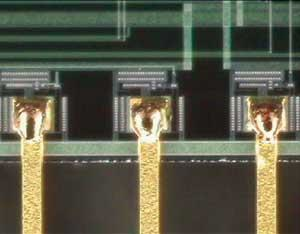 FIGURE 1. Pulsed Nd:YAG spot welds 0.005in-thick gold copper traces to metalized pad.