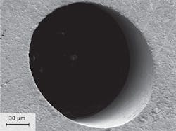 FIGURE 2. An injection nozzle hole drilled with a high-power picosecond laser and helical drilling optics has sharp edges with no burr or melt and low surface roughness inside the hole.