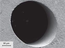 FIGURE 2. An injection nozzle hole drilled with a high-power picosecond laser and helical drilling optics has sharp edges with no burr or melt and low surface roughness inside the hole. FIGURE 2. An injection nozzle hole drilled with a high-power picosecond laser and helical drilling optics has sharp edges with no burr or melt and low surface roughness inside the hole.