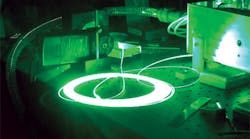 FIGURE 1. A raw coil of 100-&mu;m-core step index fiber delivering 40 W of green laser light illustrates the ability to input nearly unlimited amounts of RGB light into digital projectors and deliver up 500 W of visible light via optical fiber.