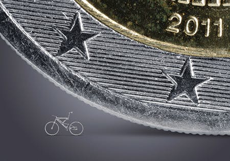 FIGURE 1. Micro bicycle cut with an ultrashort pulse laser, standing next to a 2 Euro coin for size comparison.