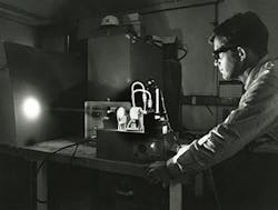 FIGURE 1. Peter Sorokin displays the first flashlamp-pumped dye laser in 1968. FIGURE 1. Peter Sorokin displays the first flashlamp-pumped dye laser in 1968.