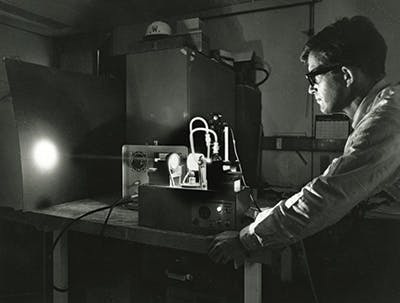 FIGURE 1. Peter Sorokin displays the first flashlamp-pumped dye laser in 1968.