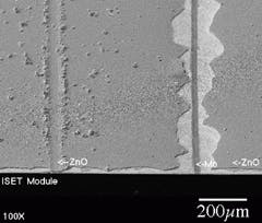 FIGURE 3. Cut on the left shows debris remaining on surface after a mechanical scribe through a 2.5-µm layer of CIGS on molybdenum (Mo) that was not carefully cleaned before being overcoated with 2.5 µm of ZnO. On the right, a 25-µm scribe in the ZnO is surrounded by a torn region 100 µm wide on each side. FIGURE 3. Cut on the left shows debris remaining on surface after a mechanical scribe through a 2.5-µm layer of CIGS on molybdenum (Mo) that was not carefully cleaned before being overcoated with 2.5 µm of ZnO. On the right, a 25-µm scribe in the ZnO is surrounded by a torn region 100 µm wide on each side.