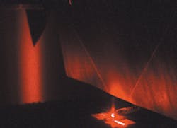 Two narrow surface beams and divergent spontaneous emission from a surface-mode-coupled semiconductor laser (bottom) strike a paper screen (top). The laser's two edge-emitted beams are visible as bright horizontal stripes below its thermoelectric cooling element. Two narrow surface beams and divergent spontaneous emission from a surface-mode-coupled semiconductor laser (bottom) strike a paper screen (top). The laser's two edge-emitted beams are visible as bright horizontal stripes below its thermoelectric cooling element.