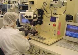 FIGURE 1. Because of their tiny size (edge-emitters usually measure about 100 µm thick by 200 to 300 µm wide by 400 to 600 µm long and VCSELs tend to measure about 300 to 400 µm square), the bonder must be equipped with special viewing capabilities, such as this cube beamsplitter and scope, to allow the operator to first see the device and then, among other things, simultaneously view the diode laser image and the site on the submount where the die is to be placed. FIGURE 1. Because of their tiny size (edge-emitters usually measure about 100 µm thick by 200 to 300 µm wide by 400 to 600 µm long and VCSELs tend to measure about 300 to 400 µm square), the bonder must be equipped with special viewing capabilities, such as this cube beamsplitter and scope, to allow the operator to first see the device and then, among other things, simultaneously view the diode laser image and the site on the submount where the die is to be placed.