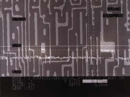 FIGURE 1. Confocal image contains a measurement of a 0.273-&micro;m photoresist line on a silicon wafer taken at a 5600X magnification, equivalent to the resolution of a scanning electron microscope. The profile overlay is taken along the horizontal solid line. The width is measured at a 50% slice level, meaning that the measurement is made at the halfway point between the bottom and top of the resist line. This slice level can be adjusted between 5% and 95%, so the width can be measured at any elevation on the side wall that is required. The height of the photoresist line is 0.29 &micro;m. The height, as well as the width, can be rapidly measured to a precision of 0.001 &micro;m. The repeatability of measurement in the horizontal and vertical direction is 0.02 &micro;m.