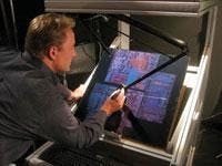 A haptic workstation offers tactile feedback derived from the 3-D information in a hologram (in this case, a city layout).