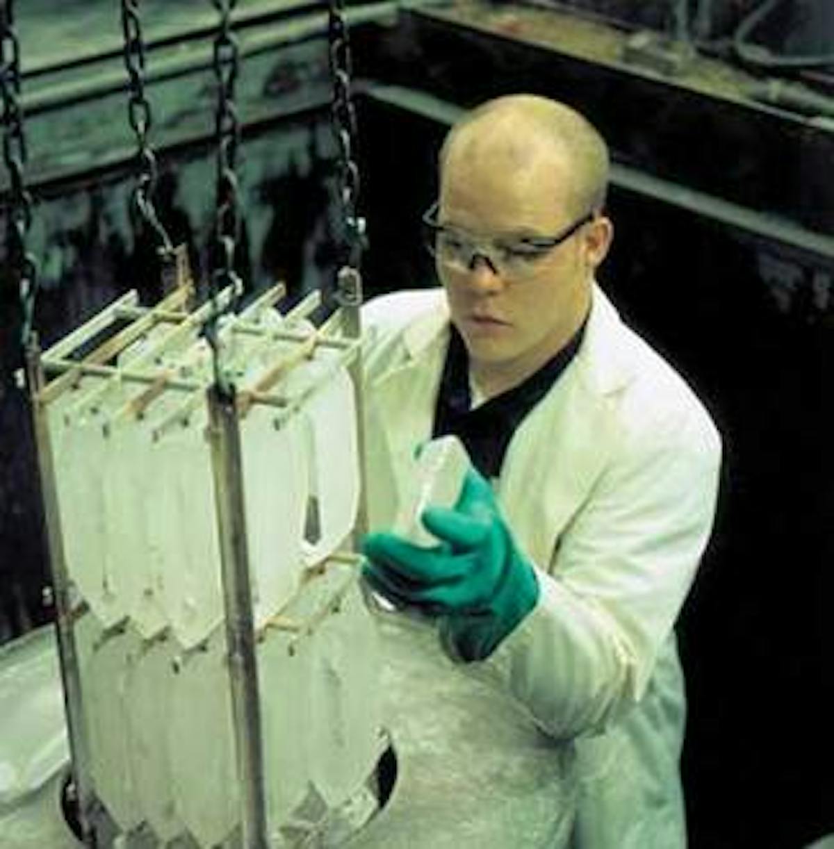 A technician inspects cultured x-plate quartz crystals. The orientation of the birefringent axes in these crystals make them well suited for use as large optical waveplates.