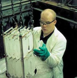 A technician inspects cultured x-plate quartz crystals. The orientation of the birefringent axes in these crystals make them well suited for use as large optical waveplates.