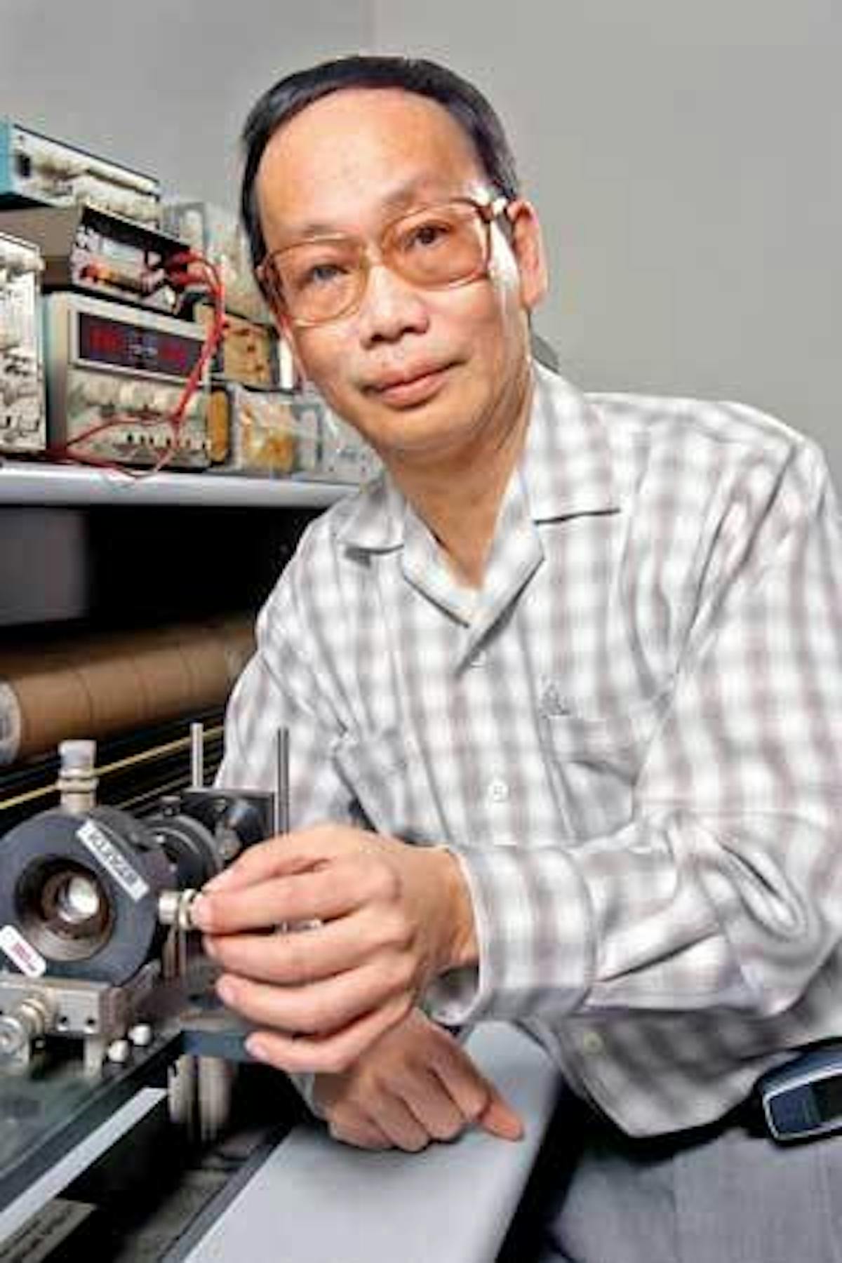 Researcher Chia Chi Teng adjusts an experiment, which he coinvented, for testing performance of organic electro-optic polymers.