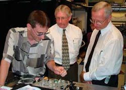 FIGURE 1. Terahertz spectrometry is moving toward compact, turnkey, user-friendly, and low-maintenance systems. The demand for such systems will come mostly from explosive sensing in the short run and biosensing in the long run. At Rensselaer Polytechnic Institute in August, author Brian Schulkin (left) demonstrated a handheld real-time (less than 0.5 s) terahertz explosive detector for Michael Troffer (right), director of explosive detection in the U.S. Navy’s explosive ordinance disposal technology division, and David McDarby, who heads nuclear security programs at the Department of Defense Threat Reduction Agency. FIGURE 1. Terahertz spectrometry is moving toward compact, turnkey, user-friendly, and low-maintenance systems. The demand for such systems will come mostly from explosive sensing in the short run and biosensing in the long run. At Rensselaer Polytechnic Institute in August, author Brian Schulkin (left) demonstrated a handheld real-time (less than 0.5 s) terahertz explosive detector for Michael Troffer (right), director of explosive detection in the U.S. Navy’s explosive ordinance disposal technology division, and David McDarby, who heads nuclear security programs at the Department of Defense Threat Reduction Agency.