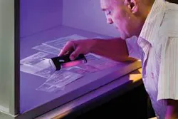 Xerox scientist Reiner Eschbach demonstrates how UV light can reveal hidden words and figures. Along with scientist Raja Bala, Eschbach is co-inventor of a process that requires no fluorescent ink, yet enables Xerox printers to individualize documents with different fluorescent words, codes, or signatures, making counterfeit copies easy to detect.