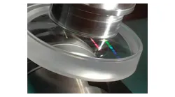 A single-point-diamond-turned asphere is polished via MRF (magnetorheological finishing). A new shape specification for axially symmetric aspheric surfaces promises to make optical design and fabrication of aspheres more straightforward.