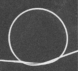 FIGURE 2. Optical-fiber nanowires can have extremely small bend radii with negligible optical loss; in the microcoil resonator shown above, the bending radius is about 45 µm, nearly a thousand times smaller than is possible with conventional telecom optical fibers. FIGURE 2. Optical-fiber nanowires can have extremely small bend radii with negligible optical loss; in the microcoil resonator shown above, the bending radius is about 45 µm, nearly a thousand times smaller than is possible with conventional telecom optical fibers.