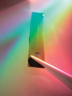 FIGURE 1. A row of glass microtoroids, each with a diameter of 75 µm, can be seen as the thin line in this picture of a silicon chip. The microtoroids are fabricated using standard semiconductor lithography techniques. FIGURE 1. A row of glass microtoroids, each with a diameter of 75 µm, can be seen as the thin line in this picture of a silicon chip. The microtoroids are fabricated using standard semiconductor lithography techniques.