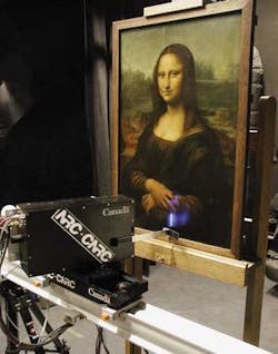 FIGURE 1. A high-resolution 3-D color laser scanner mounted on a translation stage was used to scan the Mona Lisa. The scanner uses red, green, and blue wavelengths as the laser source, which, when superimposed in the scanning system, results in the projection of a white, 50- to 100-µm-diameter laser spot on the object. FIGURE 1. A high-resolution 3-D color laser scanner mounted on a translation stage was used to scan the Mona Lisa. The scanner uses red, green, and blue wavelengths as the laser source, which, when superimposed in the scanning system, results in the projection of a white, 50- to 100-µm-diameter laser spot on the object.